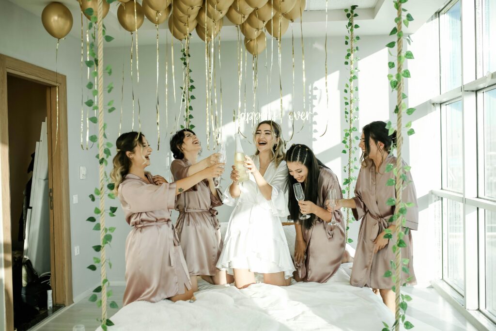 pexels-photo-9041815-9041815 Joyful bridal party enjoying champagne amidst elegant decor indoors.